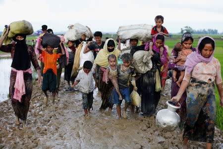A group of Rohingya refugees walk on the muddy road after travelling over the Bangladesh-Myanmar border in Teknaf, Bangladesh, September 1, 2017. REUTERS/Mohammad Ponir Hossain