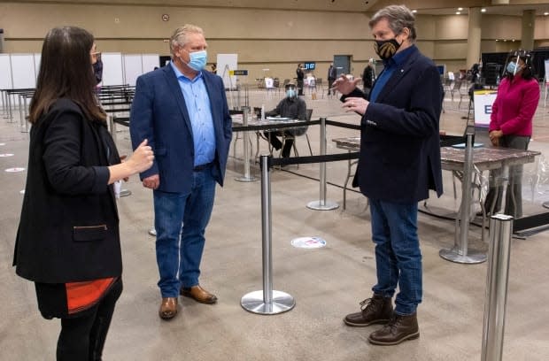 Toronto Medical Officer of Health Dr. Eileen de Villa, left, gives Ontario Premier Doug Ford, centre, and Toronto Mayor John Tory, right, a tour of a vaccination clinic for health-care workers in January. 