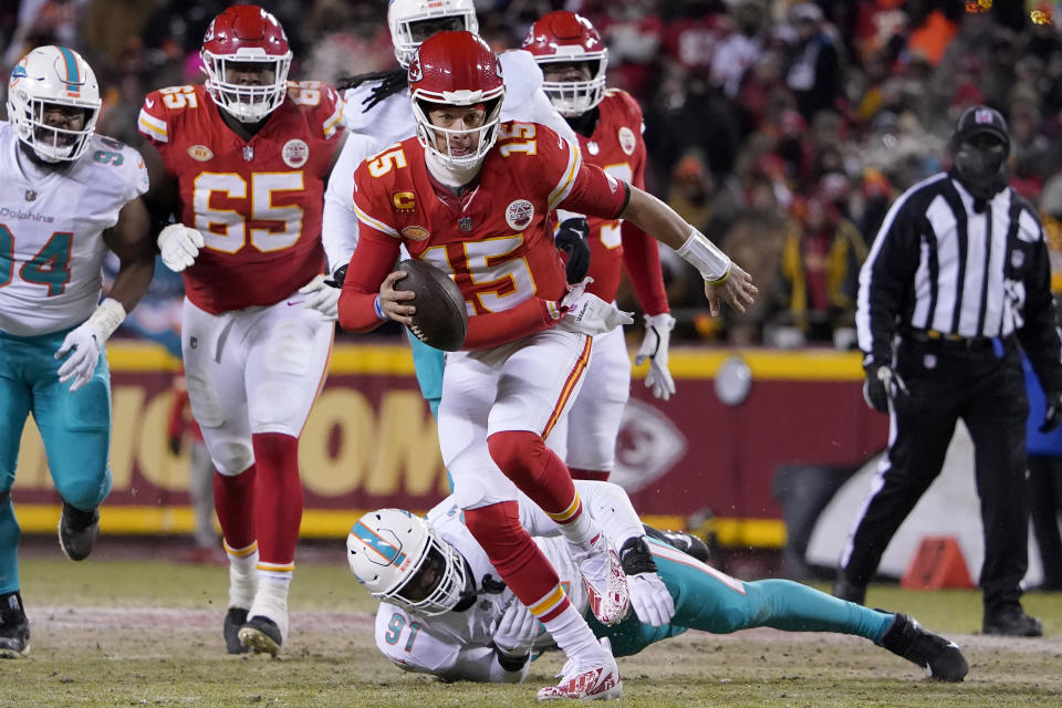 Kansas City Chiefs quarterback Patrick Mahomes (15) runs in front of Miami Dolphins defensive end Emmanuel Ogbah (91) during the first half of an NFL wild-card playoff football game Saturday, Jan. 13, 2024, in Kansas City, Mo. (AP Photo/Ed Zurga)