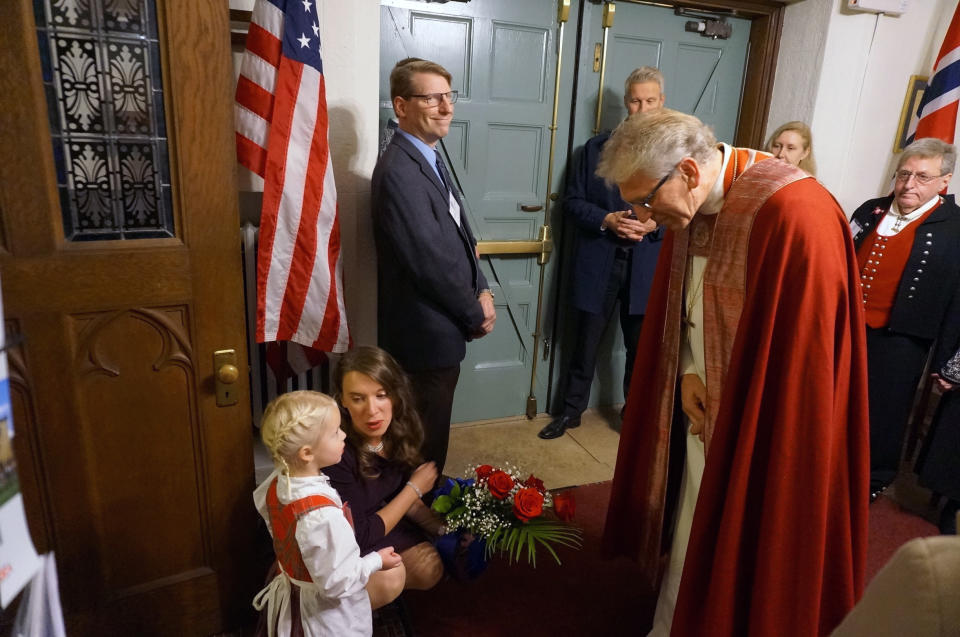 Eline Gro Knatterud, 4, meets the presiding bishop of the Church of Norway, Olav Fykse Tveit, as they both wait for Queen Sonja of Norway to arrive at Den Norske Lutherske Mindekirke, the Norwegian Lutheran Memorial Church in Minneapolis, Sunday Oct. 16, 2022. (AP Photo/Giovanna Dell'Orto)