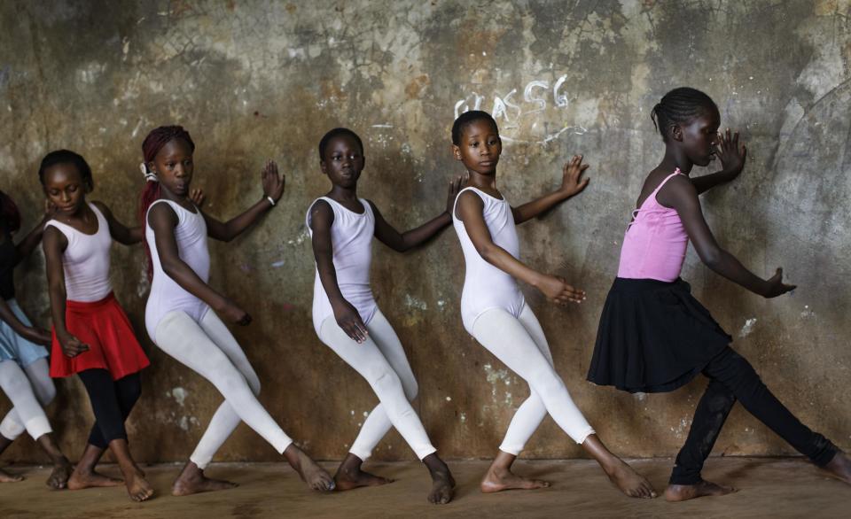 In this photo taken Friday, Dec. 9, 2016, young ballerinas practice under the instruction of Kenyan ballet dancer Joel Kioko, 16, in a room at a school in the Kibera slum of Nairobi, Kenya. In a country not usually associated with classical ballet, Kenya's most promising young ballet dancer Joel Kioko has come home for Christmas from his training in the United States, to dance a solo in The Nutcracker and teach holiday classes to aspiring dancers in Kibera, the Kenyan capital's largest slum. (AP Photo/Ben Curtis)