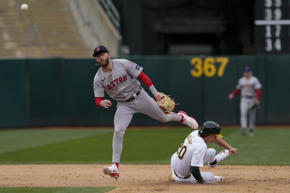 Boston Red Sox shortstop Trevor Story, left, throws to first base after forcing out Oakland Athletics' Zack Gelof at second during the eighth inning of a baseball game Wednesday, April 3, 2024, in Oakland, Calif. JJ Bleday reached first and advanced to second on Story's throwing error. (AP Photo/Godofredo A. Vásquez)
