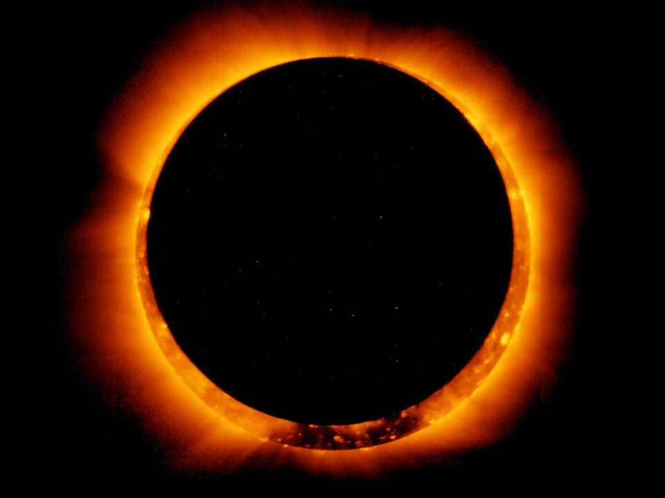 annular solar eclipse where dark circle of the moon's shadow covers the center of the sun with a ring of solar plasma peeking out around it