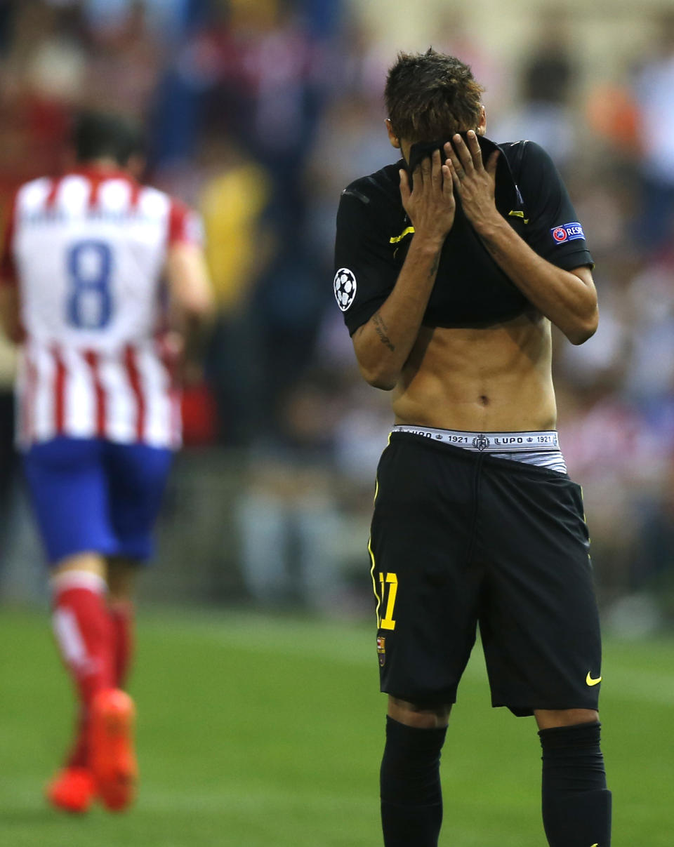 Barcelona's Neymar covers his face with his shirt during the Champions League quarterfinal second leg soccer match between Atletico Madrid and FC Barcelona at the Vicente Calderon stadium in Madrid, Spain, Wednesday, April 9, 2014. (AP Photo/Andres Kudacki)