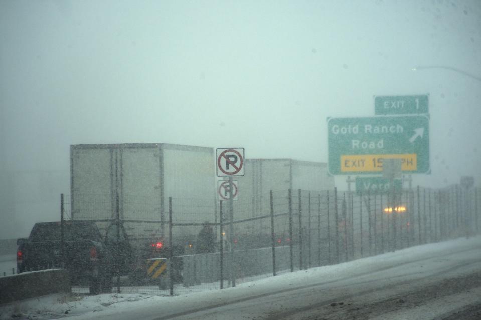 Trucks pull over to put on chains along westbound I-80 near the Nevada/California state line on March 1, 2024.