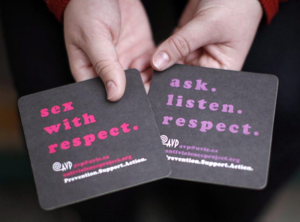 <span class="caption">In this 2016 photo, a University of Victoria student holds coasters with messages about consensual sex.</span> <span class="attribution"><span class="source">THE CANADIAN PRESS/Chad Hipolito</span></span>