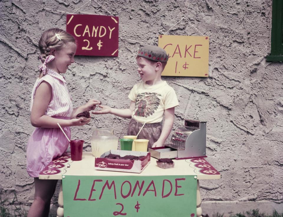 <span>A young boy sets up a stall selling cake, candy and lemonade to his neighbors, 1955.</span><span>Photograph: Lambert/Getty Images</span>