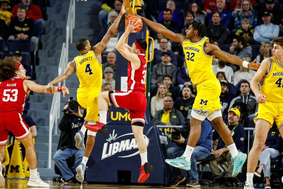 Nebraska guard Keisei Tominaga makes a layup against Michigan's Nimari Burnett and Tarris Reed Jr. during the first half at Crisler Center in Ann Arbor on Sunday, March 10, 2024.