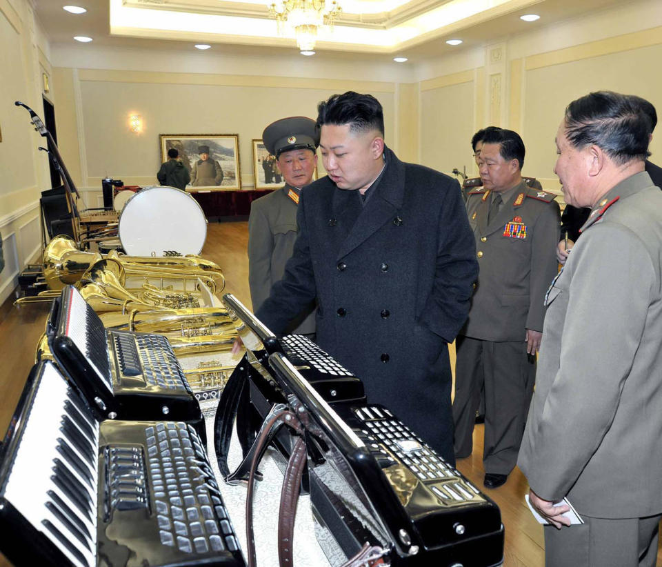 This undated photo released by North Korea's official KCNA via the KNS on March 25, 2013 shows North Korean leader Kim Jong-Un (C) looking at musical instruments manufactured by the Korean People's Army at an undisclosed location in North Korea.