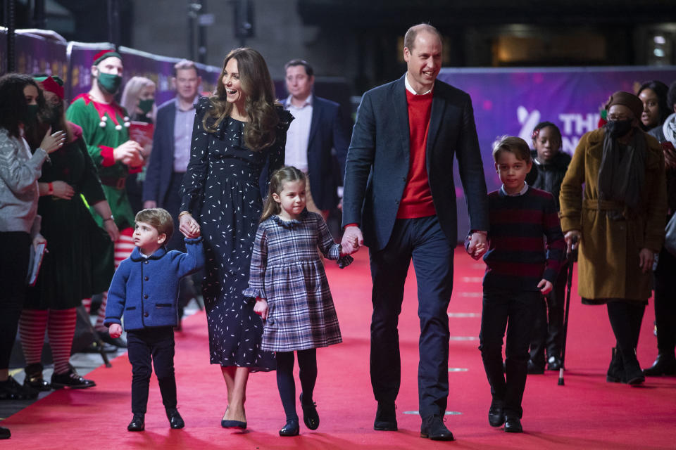 FILE - In this Friday Dec. 11, 2020 file photo, Britain's Prince William and Kate, The Duke and Duchess of Cambridge and their children, Prince Louis, left, Princess Charlotte and Prince George arrive for a special pantomime performance at London's Palladium Theatre. One of the most dramatic claims in Prince Harry and Meghan's interview with Oprah Winfrey was that their son was denied a royal title, possibly because of the color of his skin. Queen Elizabeth II has nine great-grandchildren, including Archie. They are not princes and princesses, apart from the three children of Prince William, who is second in line to the throne and destined to be king one day. (Aaron Chown/Pool via AP, file)