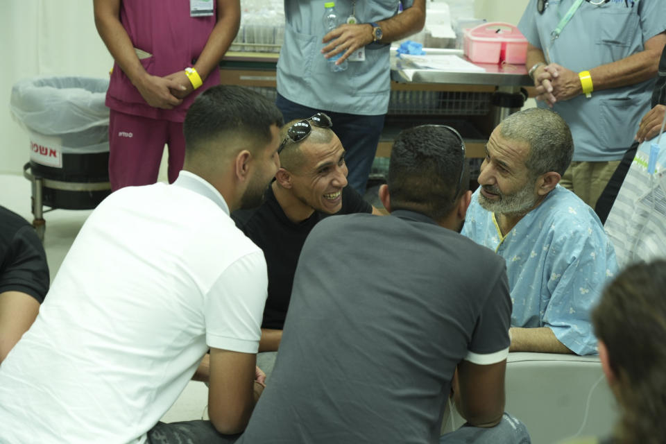 In this photo released by the Israel Prime Minister Office on Tuesday, Aug. 27, 2024, Kaid Farhan Al-Qadi, 52, right, who was held hostage by Hamas militants in Gaza sits in a room at the Soroka Medical Center in Beersheba, Israel. (Israel Prime Minister Office via AP)