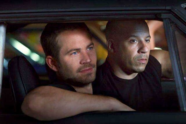 Paul Walker and Vin Diesel sitting in a car in Fast Five