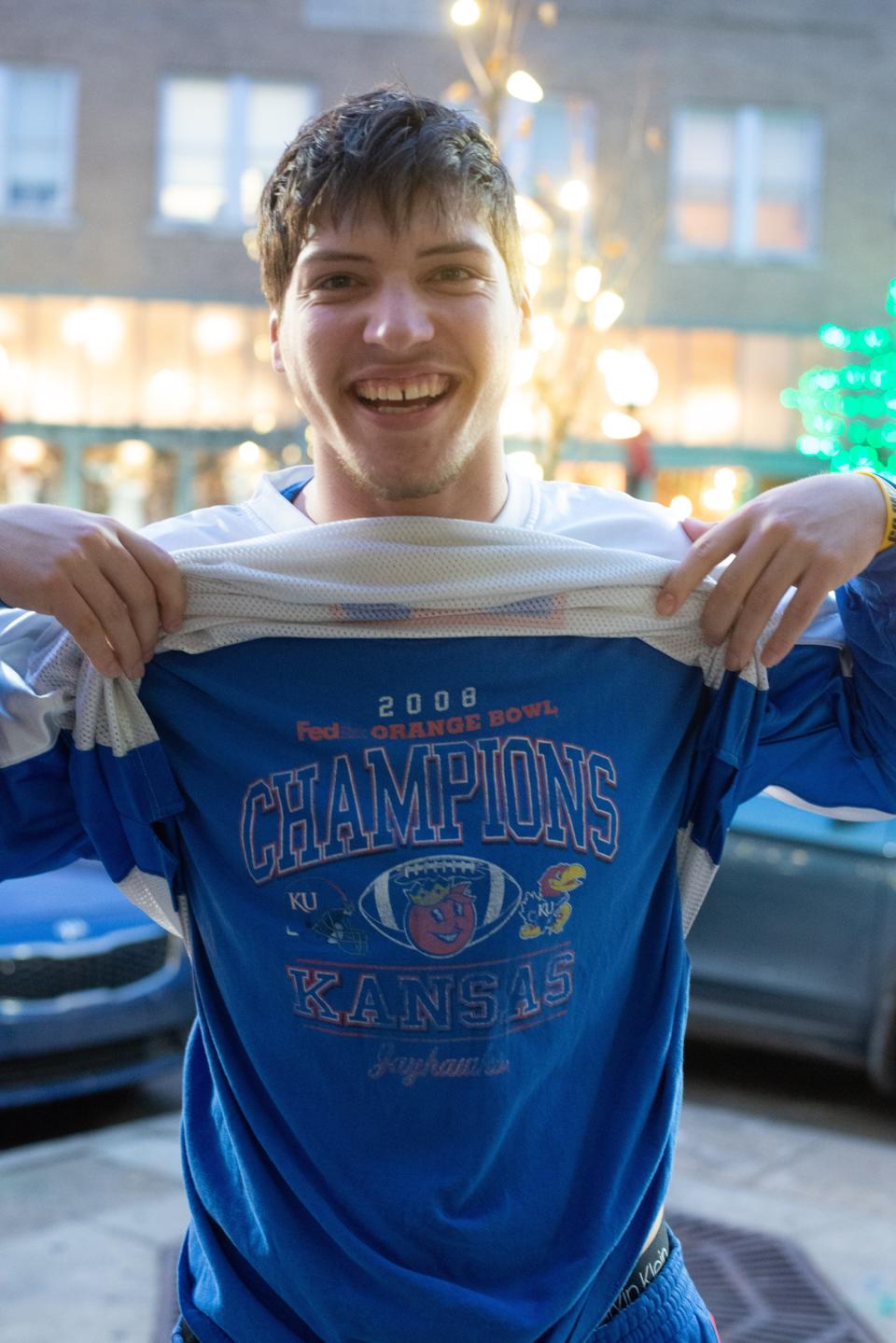 Lawrence resident Casey Graver shows off his original 2008 Orange Bowl T-shirt he wore under a football jersey to watch Kansas take on Arkansas in the Liberty Bowl.