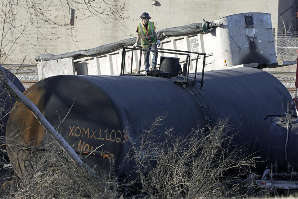 FILE - A cleanup worker stands on a derailed tank car of a Norfolk Southern freight train in East Palestine, Ohio, continues, Feb. 15, 2023. After the catastrophic train car derailment in East Palestine, Ohio, some officials are raising concerns about a type of toxic substance that tends to stay in the environment. (AP Photo/Gene J. Puskar, File)