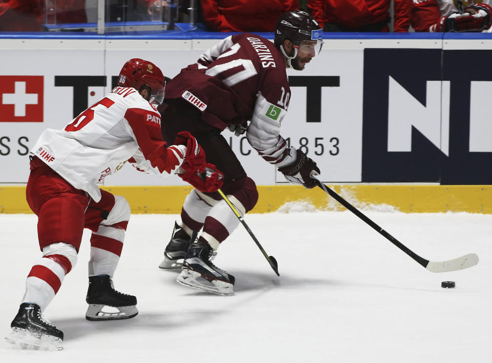 Russia's Nikita Kucherov checks Latvia's Lauris Darzins, from left, during the Ice Hockey World Championships group B match between Latvia and Russia at the Ondrej Nepela Arena in Bratislava, Slovakia, Saturday, May 18, 2019. (AP Photo/Ronald Zak)