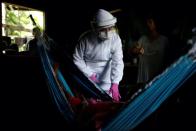 La doctora Marilia Correa atiende a Maria de Nazare, de 80 años, mientras esta descansa en una hamaca en su casa de Pinheiro. (Foto: Uesley Marcelino / Reuters).