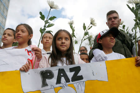 FILE PHOTO: People take part in a rally against violence, following a car bomb explosion, in Bogota, Colombia January 20, 2019. The placard reads, "Peace". REUTERS/Luisa Gonzalez/File Photo