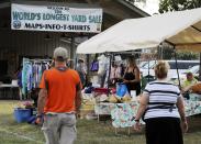 A crowd looks through items at the World's Longest Yard Sale, which stretches from Alabama to Michigan, at its southernmost point in Gadsden, Ala., on Thursday, Aug. 6, 2020. Promoters considered canceling the four-day sale because of the coronavirus pandemic but decided to go ahead with the event, now in its 34th year. (AP Photo/Jay Reeves)