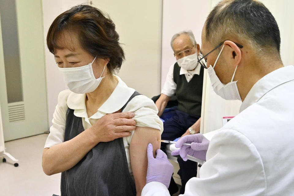 An elderly woman receives her first dose of Pfizer's COVID-19 vaccine at a clinic in Kitaaiki village, Nagano prefecture, central Japan, Monday, April 12, 2021. Japan started its vaccination drive with medical workers and expanded Monday to older residents, with the first shots being given in about 120 selected places around the country. (Yohei Nishimura/Kyodo News via AP)