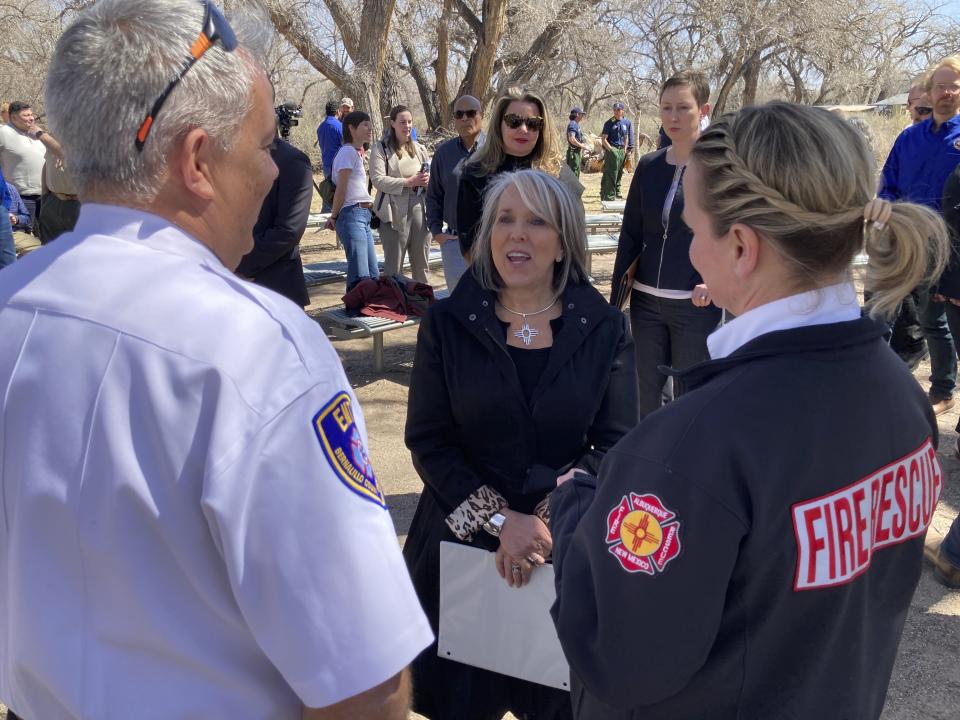 New Mexico Gov. Michelle Lujan Grisham, center, talks with Albuquerque Fire Chief Emily Jaramillo, right, and Bernalillo County Fire Chief Greg Perez, left, following a news conference at the Rio Grande Nature Center State Park in Albuquerque, N.M., Wednesday, March 29, 2023. Fire managers are urging caution ahead of the wildfire season as parts of the Southwestern U.S. remain dry. (AP Photo/Susan Montoya Bryan)