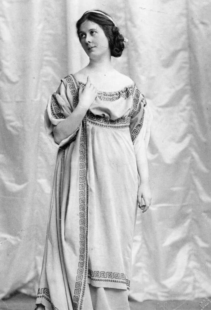 Isadora Duncan stands in a Grecian costume looking wistfully off-camera