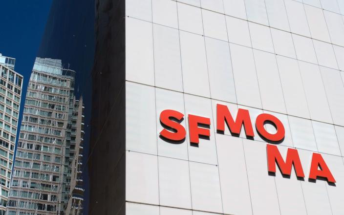 A view of SFMOMA&#x27;s white facade, bearing the museum&#x27;s logo in red letters