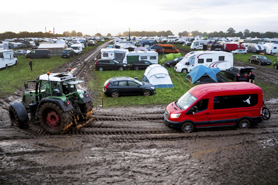 A vehicle is pulled through the mud with the help of a tractor onto the grounds of the heavy metal festival in Wacken, Germany, Wednesday, Aug. 2, 2023. The Wacken Open Air metal festival in northern Germany is opening with a reduced audience after persistent rain turned the grounds to mud and forced organizers to order a halt to all new arrivals. Organizers of the famed music festival, in a rural area northwest of Hamburg, had already told fans on Tuesday that no more cars and trucks could be admitted to the site. (Daniel Bockwoldt/dpa via AP)