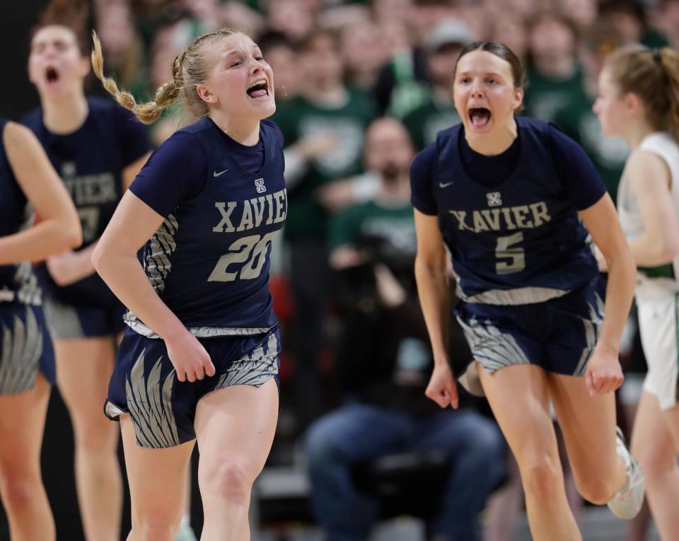 Xavier's Elle Krull (20) and Joy Krull (5) celebrate the Hawks' victory against Kettle Moraine Lutheran during their WIAA Division 3 girls state semifinal basketball game Thursday at the Resch Center in Ashwaubenon.