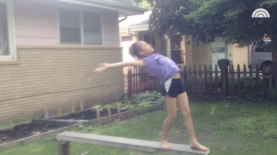 A young Sunisa Lee flips on her backyard balance beam.