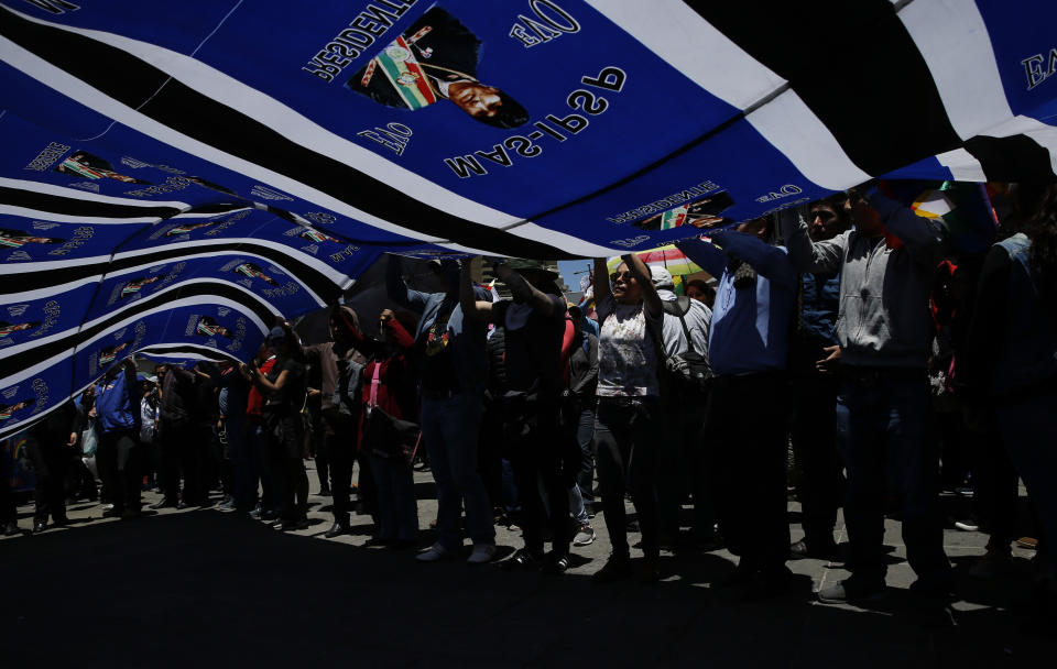 Supporters of Bolivian President Evo Morales march in La Paz, Bolivia, Wednesday, Oct. 23, 2019. Morales said Wednesday his opponents are trying to stage a coup against him as protests grow over a disputed election he claims he won outright, though a nearly finished vote count suggests it might head to a second round. (AP Photo/Juan Karita)