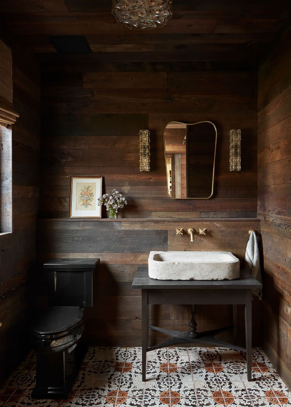 a bathroom with a wood paneled wall