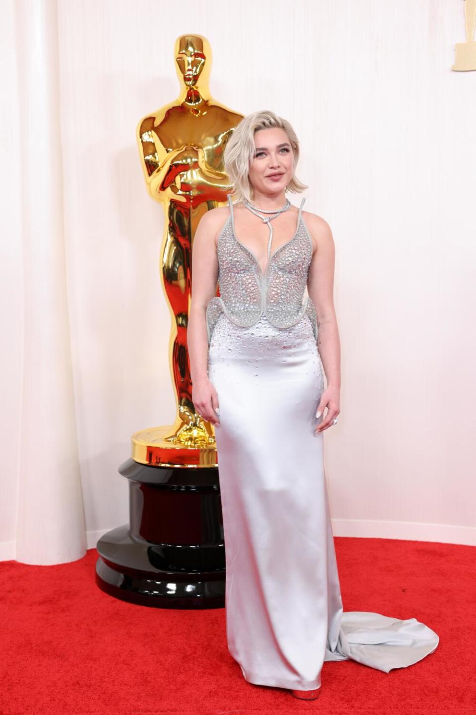 Florence Pugh wears a silver satin gown.