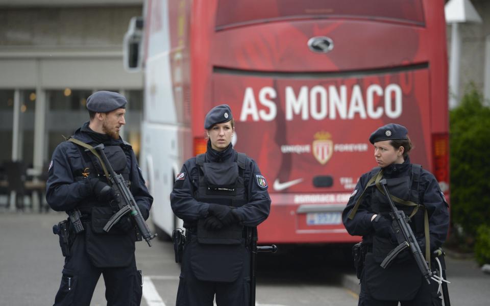 Policemen stand guard in front of a team bus of French football club AS Monaco - Credit: SASCHA SCHUERMANN/AFP