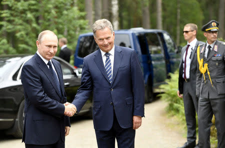 Finnish President Sauli Niinisto (R) welcomes Russian President Vladimir Putin at the Hotel Punkaharju in Savonlinna, Eastern Finland July 27, 2017. Lehtikuva/Martti Kainulainen/via REUTERS