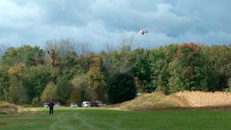 A helicopter circles the site of a small plane crash near Pembroke N.Y., Friday, Oct. 2, 2020. Two people aboard the aircraft died. Attorney Stephen Barnes and his niece were killed in the crash.
