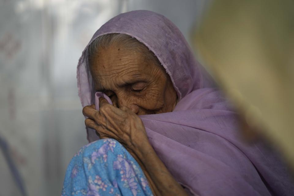 A woman, who lost seven relatives to a bridge collapse, wipes her tears as she mourns at in Morbi town of western state Gujarat, India, Tuesday, Nov. 1, 2022. Shock and anger have been supplanted by grief as families and friends mourn the 134 lives lost when a suspension bridge collapsed Sunday in the western Indian city of Morbi. It was one of the country’s worst disasters in years. (AP Photo/Rafiq Maqbool)