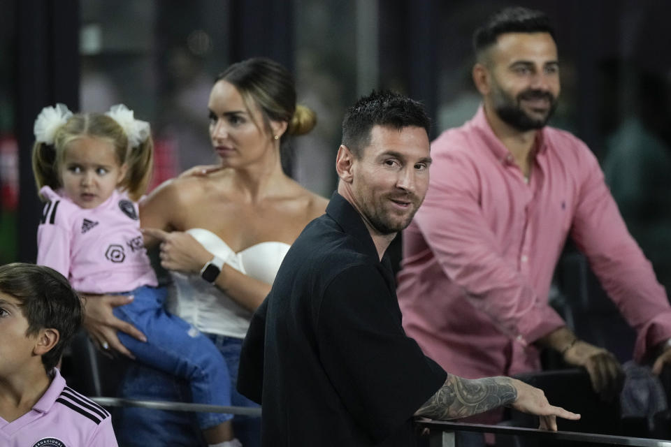 Inter Miami forward Lionel Messi, front, greets friends inside a private box at the start of the team's U.S. Open Cup final soccer match against the Houston Dynamo, Wednesday, Sept. 27, 2023, in Fort Lauderdale, Fla. (AP Photo/Rebecca Blackwell)