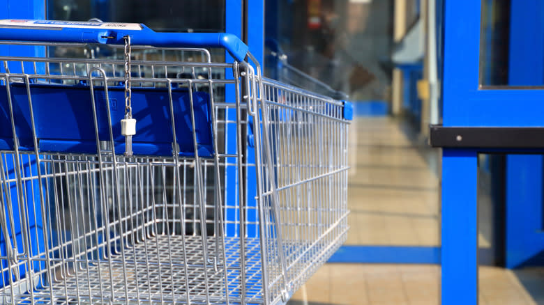 shopping cart with key in front of blue doors
