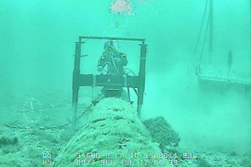 A diver is seen working along the submerged portion of Enbridge’s Line 5 pipeline in the Straits of Mackinac.