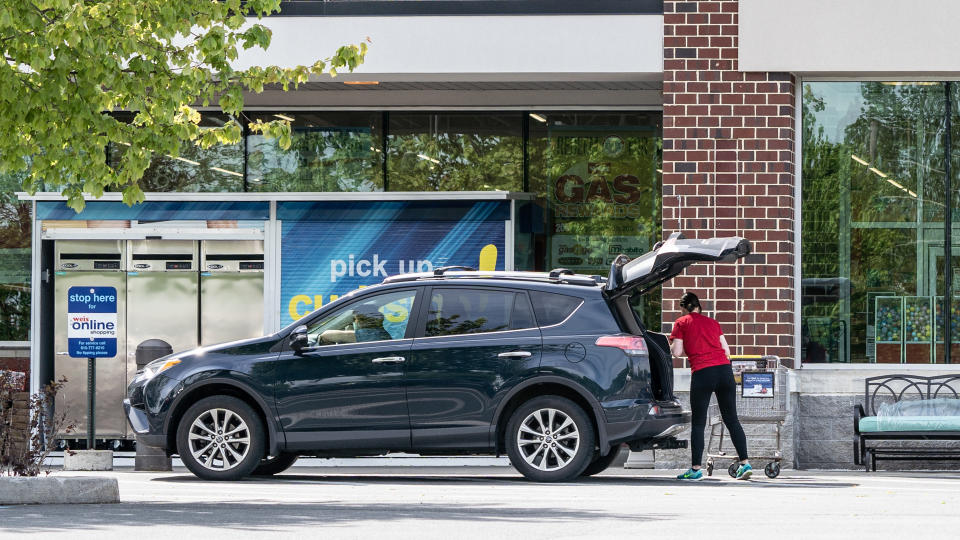 Berks County, Pennsylvania, USA - May 19, 2020: Employee puts groceries in customers car at Weis Markets curb side pick-up.