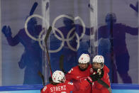 Switzerland's Lara Stalder (7) celebrates with Alina Muller (25) and Phoebe Staenz (88) after Stalder scored a goal against Canada during a women's semifinal hockey game at the 2022 Winter Olympics, Monday, Feb. 14, 2022, in Beijing. (AP Photo/Petr David Josek)