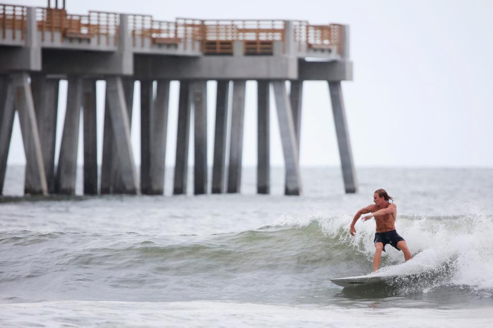 Charlie Current squeezes in a quick surf session Thursday near the Jacksonville Beach pier.