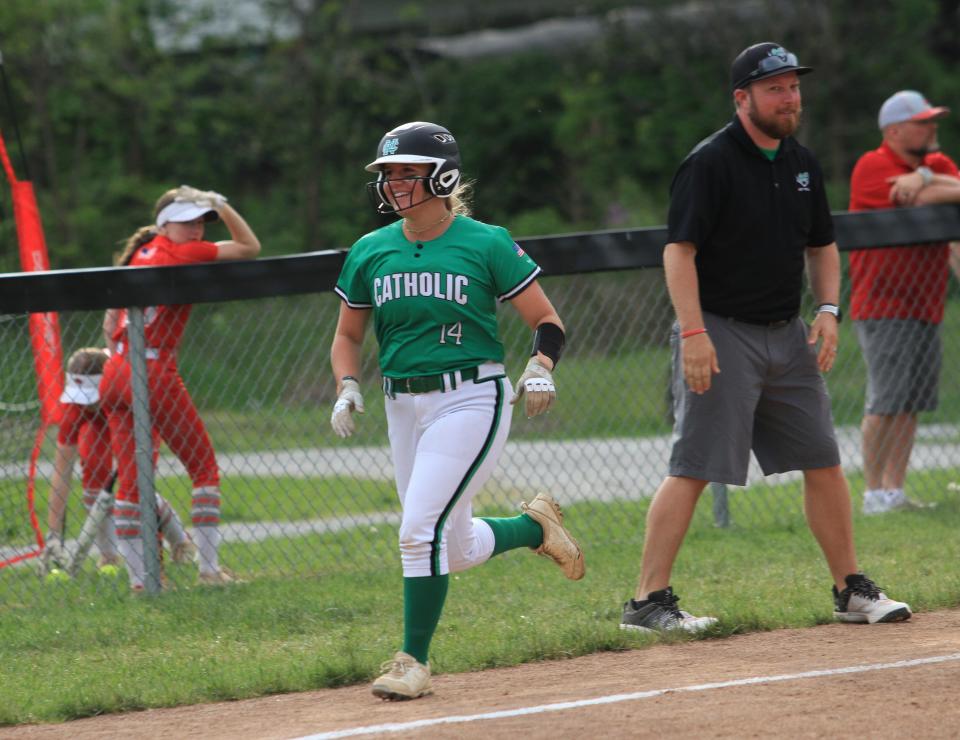 Newark Catholic's Mary Snider smiles as she heads home following hitting a home run against Johnstown on Friday.
