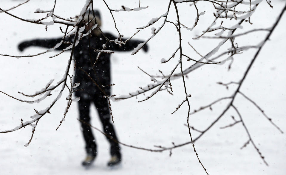 A person skates on the Frog Pond rink on Boston Common in Boston, Tuesday, Feb. 18, 2014. It was expected to drop 3 to 5 inches of snow on Boston, with 6 to 10 inches forecast for parts of Northern New England, before moving out late Tuesday and early Wednesday. (AP Photo/Michael Dwyer)