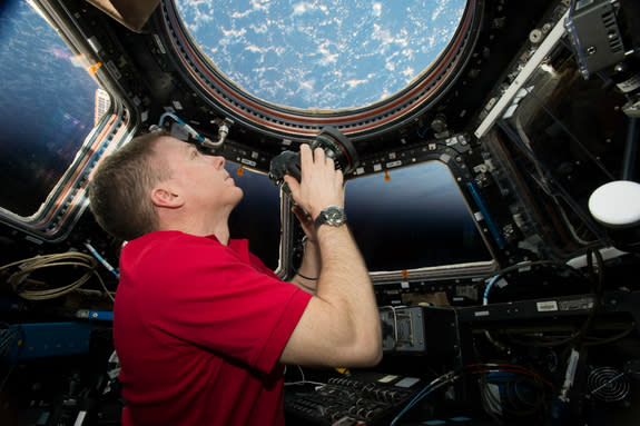 Onboard the International Space Station (ISS) – NASA Commander Terry Virts shoots through the window of the ISS's Cupola Observation Module.