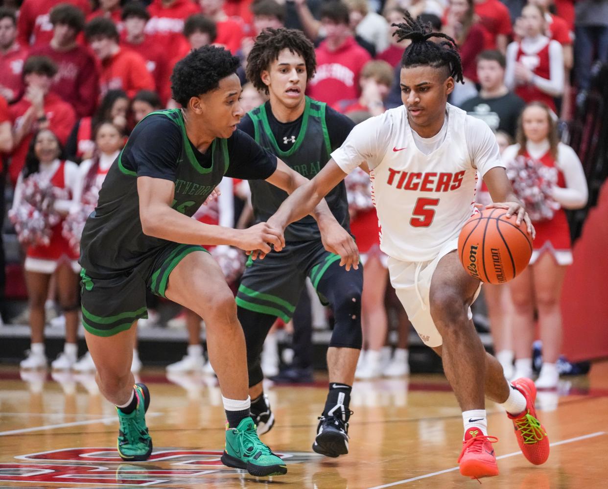 Fishers Tigers Jason Gardner (5) rushes up the court against Cathedral Fighting Irish Anthony Fields (13) on Friday, Feb. 9, 2024, during the game at Fishers High School in Fishers. The Fishers Tigers defeated the Cathedral Fighting Irish, 56-51.