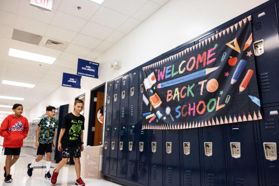 Students walk past a sign that says Welcome Back to School during the first day of school at Lake Norman Charter Middle School in Huntersville, N.C., on Thursday, August 10, 2023.