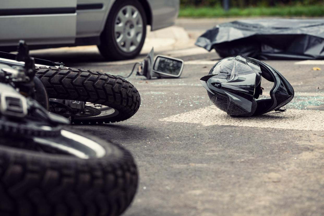 Traffic accident between motorcycle and car, helmet on the street