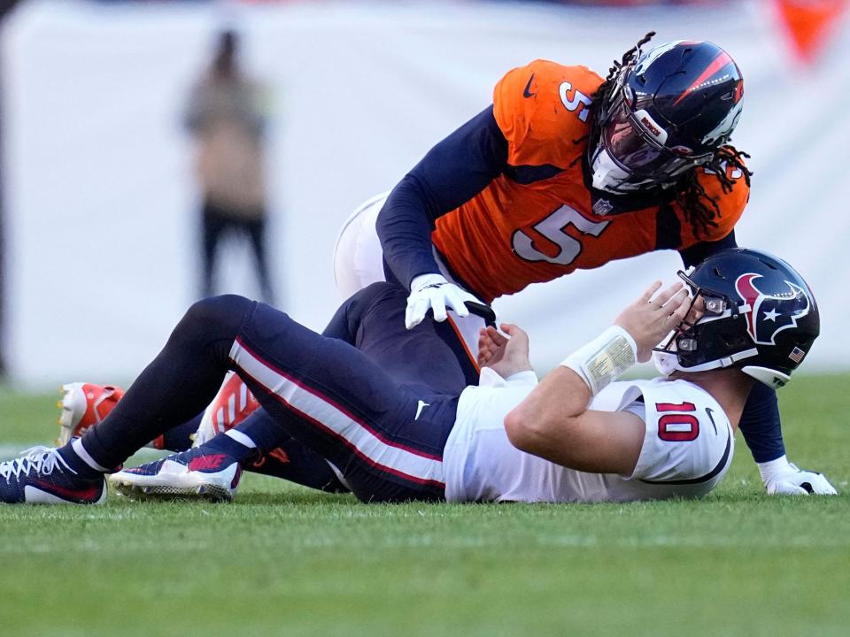 Davis Mills takes a hit against the Denver Broncos.