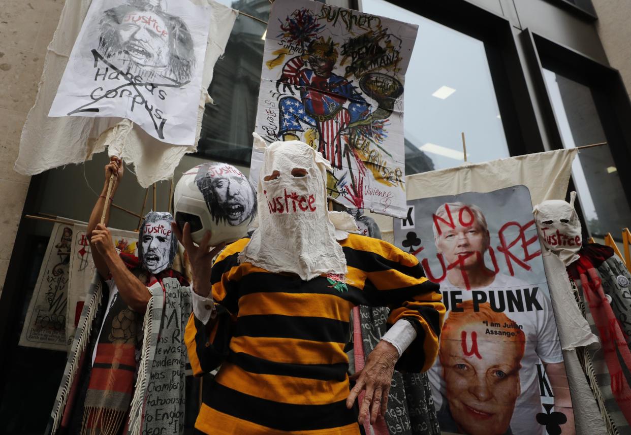 British fashion designer Vivienne Westwood, center, with her head covered, poses for photos during a protest to support Julian Assange outside the Central Criminal Court Old Bailey in London, England on Monday, Sept. 7, 2020.